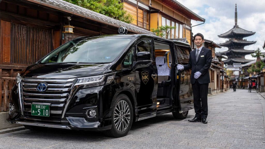 A clean Kyoto taxi with a driver in white gloves, showing senior-friendly transport.