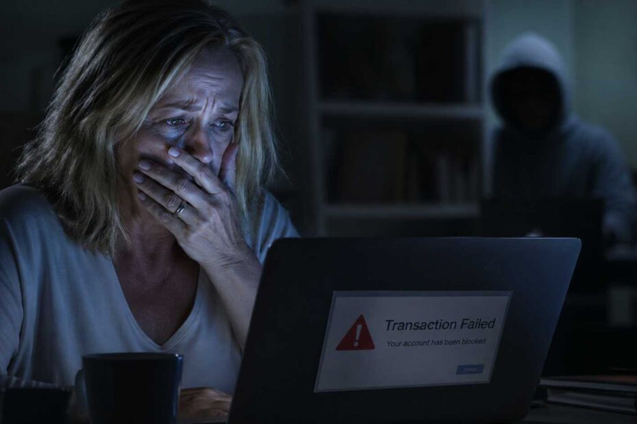 A senior woman reacting to a remote job scam red flag on her computer.